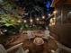 Backyard patio featuring an outdoor fireplace, Adirondack chairs, and soft lighting at 1833 N Rock Springs Ne Rd, Atlanta, GA 30324
