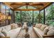Relaxing sunroom features vaulted ceiling, comfortable couches, stylish accents, and views of verdant landscape at 1833 N Rock Springs Ne Rd, Atlanta, GA 30324