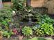 A stone waterfall and pond are surrounded by lush greenery and a wooden fence at 1833 N Rock Springs Ne Rd, Atlanta, GA 30324