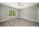 Sunlit bedroom with wood-look flooring, white trim, and a large window overlooking the trees at 4140 Camaron Way, Snellville, GA 30039