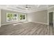 Bright bedroom with tray ceiling, ceiling fan, hardwood floors and natural light from the windows at 4140 Camaron Way, Snellville, GA 30039