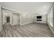 Bright living room features a stone accent wall with a modern fireplace, wood-look flooring, and large windows at 4140 Camaron Way, Snellville, GA 30039