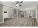 Spacious living room featuring wood-look flooring, white trim, and access to the staircase, kitchen, and entryway at 4140 Camaron Way, Snellville, GA 30039