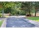 View of community gate with black iron bars along a dark paved road at 5069 Kathryn Glen Dr, Acworth, GA 30101