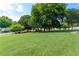 Expansive green space with lush trees and community homes visible in the background on a sunny day at 5069 Kathryn Glen Dr, Acworth, GA 30101