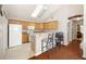 Kitchen with hardwood floors, breakfast bar, white appliances, and wooden cabinets at 5069 Kathryn Glen Dr, Acworth, GA 30101