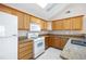 Kitchen featuring wooden cabinets, stainless steel sink, and white appliances at 5069 Kathryn Glen Dr, Acworth, GA 30101