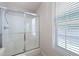 This bathroom features a clean shower area enclosed with glass doors, paired with a window for natural light at 5069 Kathryn Glen Dr, Acworth, GA 30101
