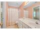 Bathroom with a double sink vanity, peach wallpaper, and a shower-tub combo at 1765 Redbud Way, Cumming, GA 30041