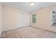 Bedroom with neutral walls, carpet flooring, a double door closet, and a window to the outside at 1765 Redbud Way, Cumming, GA 30041