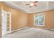 Bright primary bedroom featuring carpet flooring, tray ceiling, and a large window at 1765 Redbud Way, Cumming, GA 30041