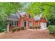 Attractive brick home with a two-car garage, front yard with mature shrubbery at 1765 Redbud Way, Cumming, GA 30041