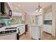 Open-concept kitchen with a center island, white cabinets, and backyard views at 1765 Redbud Way, Cumming, GA 30041
