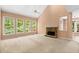 Spacious living room with a vaulted ceiling, stone fireplace, and large windows overlooking the backyard at 1765 Redbud Way, Cumming, GA 30041