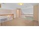 Open loft area with neutral carpet and a view of the landscaped backyard through the windows at 1765 Redbud Way, Cumming, GA 30041