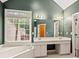 Well-lit bathroom featuring a double vanity, soaking tub, and large window at 1765 Redbud Way, Cumming, GA 30041