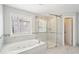 Bright bathroom features a tub with jets and a glass enclosed shower at 2359 Saint Kennedy Ln, Buford, GA 30518