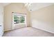 Bright bedroom with large window, neutral carpet, and vaulted ceiling with fan at 2359 Saint Kennedy Ln, Buford, GA 30518