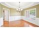 This dining room features hardwood floors, wainscoting, designer lighting and plenty of natural light at 2359 Saint Kennedy Ln, Buford, GA 30518