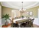 This dining room features hardwood floors, wainscoting, designer lighting and is virtually staged at 2359 Saint Kennedy Ln, Buford, GA 30518