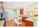 Bright kitchen features wood floors, island, stainless appliances, granite countertops and is open to the living room at 2359 Saint Kennedy Ln, Buford, GA 30518