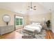 Staged primary bedroom features a vaulted ceiling, wood floors, area rug, bench and windows at 2359 Saint Kennedy Ln, Buford, GA 30518