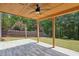 Covered patio with fan, lighting, and wood-look tile overlooks backyard at 2359 Saint Kennedy Ln, Buford, GA 30518