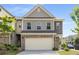 Beautiful townhome featuring brick accents, a two-car garage, and lush landscaping at 2829 Wild Laurel Ct, Norcross, GA 30071
