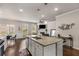 Kitchen island with sink, granite countertop and pendant lights overlooking the living area at 2829 Wild Laurel Ct, Norcross, GA 30071