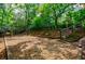 Backyard view of a swing set and wood stairs leading to green foliage, trees, and landscaping at 3030 Spalding Dr, Sandy Springs, GA 30350