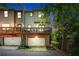Townhome with a private deck, an attached garage, and a brick foundation at dusk at 1325 Oakview Rd, Decatur, GA 30030