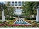 Luxury building exterior with water feature surrounded by colorful flower garden and lush green trees at 3324 Peachtree Ne Rd # 2718, Atlanta, GA 30326