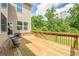 Wooden back deck with brick trim overlooking lush green yard with trees at 5515 Cheatam Ave, Cumming, GA 30040