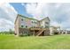 Spacious backyard featuring a deck with stairs, lush green lawn, and a well-maintained exterior at 5515 Cheatam Ave, Cumming, GA 30040
