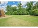 Lush backyard features green grass and mature trees from stairs at 5515 Cheatam Ave, Cumming, GA 30040