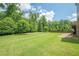 Large, well-maintained backyard with mature trees and a spacious green lawn, ideal for outdoor activities at 5515 Cheatam Ave, Cumming, GA 30040