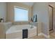 Modern bathroom featuring a soaking tub, a walk-in glass shower, and neutral tile at 5515 Cheatam Ave, Cumming, GA 30040
