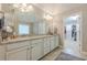 Bathroom featuring double vanities with granite counters, a large mirror, white cabinets and walk-in closet at 5515 Cheatam Ave, Cumming, GA 30040