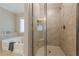 Walk-in glass shower with neutral tile, with soaking tub near by at 5515 Cheatam Ave, Cumming, GA 30040