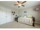 Neutral bedroom with a ceiling fan, closet, and daybed with colorful pillows and artwork at 5515 Cheatam Ave, Cumming, GA 30040