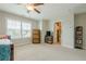 Neutral bedroom with window, daybed, cabinet, and doorway to the adjoining bathroom at 5515 Cheatam Ave, Cumming, GA 30040
