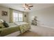 Bright bedroom featuring a window with decorative curtains, carpet flooring, and ceiling fan at 5515 Cheatam Ave, Cumming, GA 30040