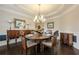 Elegant dining room with hardwood floors, decorative molding, chandelier, and ample seating for formal dinners at 5515 Cheatam Ave, Cumming, GA 30040