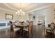 Formal dining room featuring hardwood floors, chandelier, and views into the living area at 5515 Cheatam Ave, Cumming, GA 30040