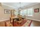 Bright dining area features a wooden table, modern chandelier, and large windows with shutters at 5515 Cheatam Ave, Cumming, GA 30040