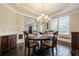 Dining room featuring a beautiful chandelier, hardwood floors, and natural light from the windows at 5515 Cheatam Ave, Cumming, GA 30040