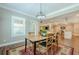 Dining area leads to an open-concept design, enhanced with modern lighting and hardwood floors at 5515 Cheatam Ave, Cumming, GA 30040