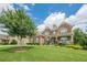 Lovely two-story brick home with a manicured front lawn, trees, and welcoming porch at 5515 Cheatam Ave, Cumming, GA 30040