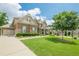 Lovely two-story brick home with a three car garage, long driveway and sprawling green lawn at 5515 Cheatam Ave, Cumming, GA 30040
