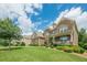 Beautiful two-story brick home with a manicured front lawn and a welcoming porch with chairs at 5515 Cheatam Ave, Cumming, GA 30040